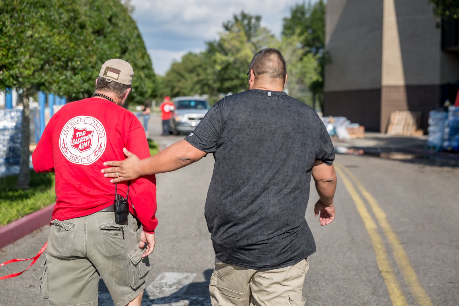 Salvation Army volunteer walking with a man.